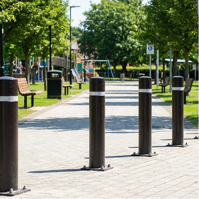 Bollards on a sidewalk with a park in the background