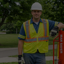Man in safety vest and hard hat standing outdoors with a 'Man Saver' product.